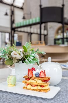 Mille Feuille with tea set on table in cafe.
