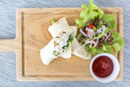 Chicken wrap with fresh vegetable on table.