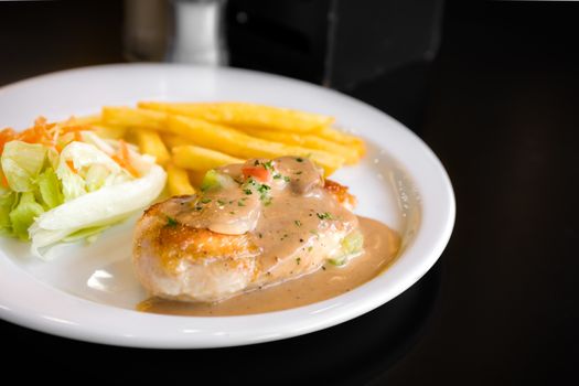Grilled chicken steak with vegetable salad and fries.