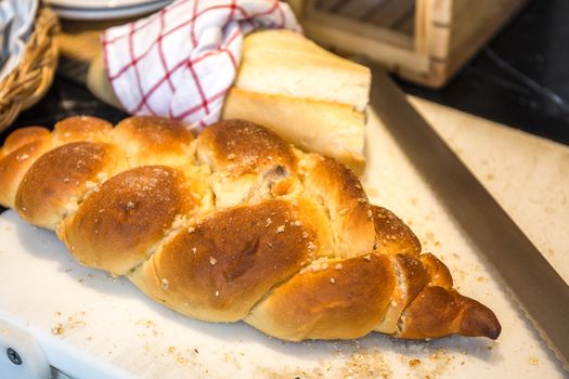 Loaf of bread with knife on block in HDR.