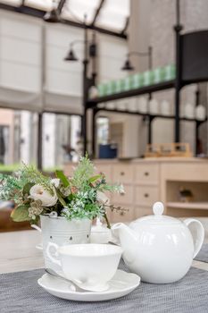 White English tea set on table in cafe.