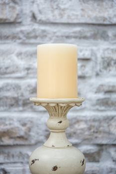 Vintage candlestick with stone wall background in HDR.