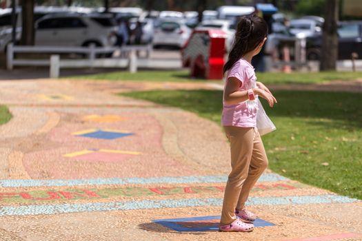 Child walking in park alone in afternoon.