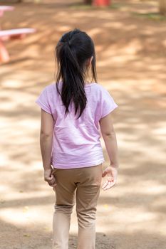 Back view of lonely child in playground.