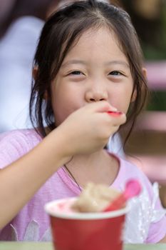 Kid eating ice cream with happy face.