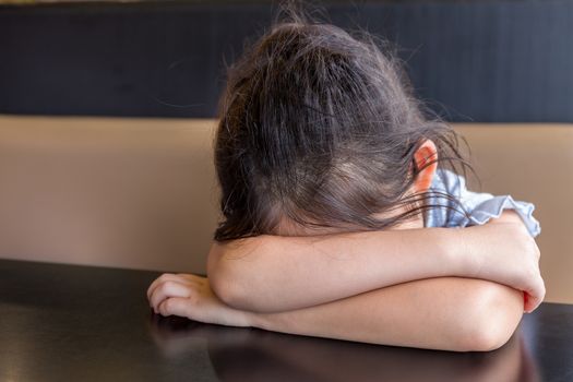 Tired child sleeping on desk or table.