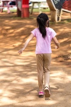 Rear view of lonely child in playground.