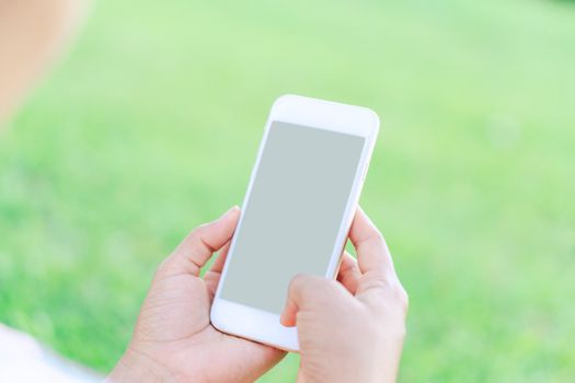 Closeup woman hand playing smartphone mobile with relaxing feelling, selective focus