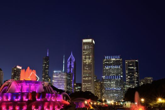 Chicago skyline panorama with skyscrapers and Buckingham fountain at night.