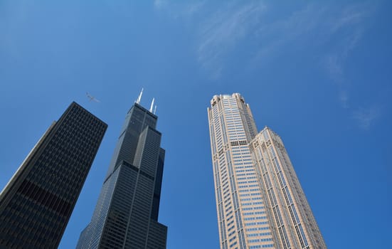 Detail of modern skyscrapers in Chicago with an airplane through the sky, Illinois, USA.