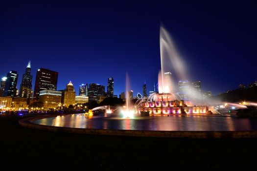 Chicago skyline panorama with skyscrapers and Buckingham fountain at night.