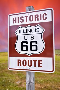 Historic Illinois Route 66 brown sign with sunset.