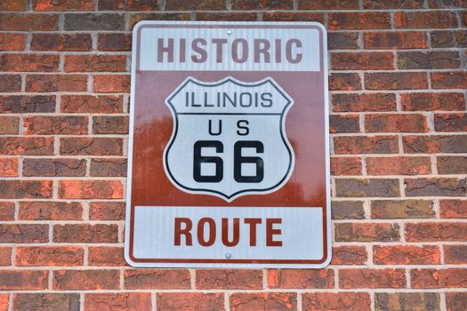 Historic Route 66 road sign painted on a brick wall in Illinois