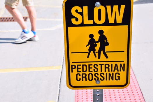 Slow pedestrian crossing yellow sign.