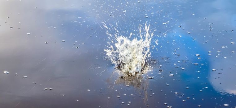 Beautiful water at a lake with splashing water and ripples on the surface with clouds and sky reflections