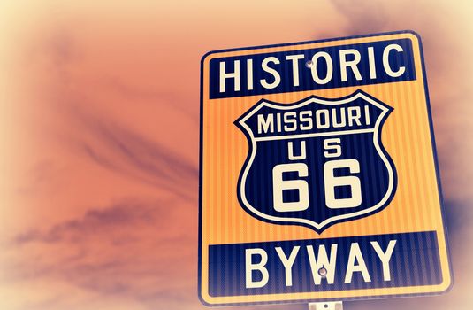 Historic route 66 highway sign in Missouri USA. Red sky background