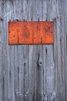 Rusty metal sign on wooden wall, copy space.