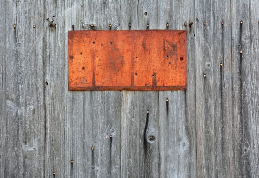 Rusty metal sign on wooden wall, copy space.