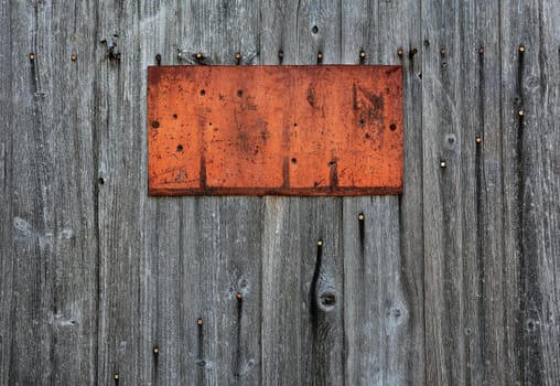Rusty metal sign on wooden wall, copy space.