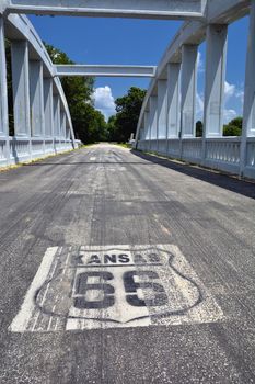 Close up of this Rainbow Curve Bridge Constructed in 1923 that is the only remaining Marsh Arch Bridge on Route 66. Route 66 signs are painted on the pavement.