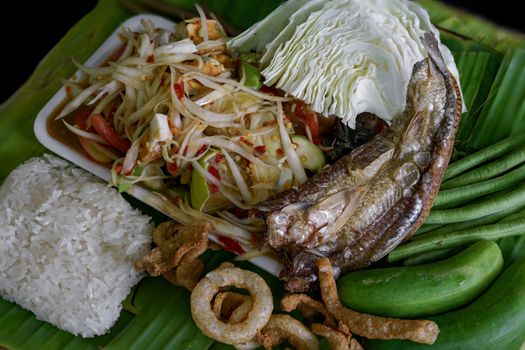 Isan Thai food Name papaya salad, pickled fish, salted egg With various machines Green banana leaf background