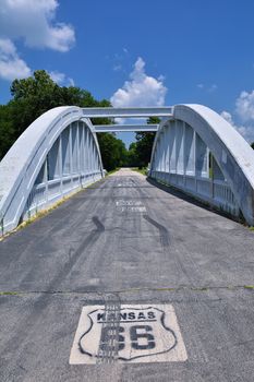 Close up of this Rainbow Curve Bridge Constructed in 1923 that is the only remaining Marsh Arch Bridge on Route 66. Route 66 signs are painted on the pavement.