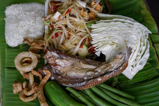 Isan Thai food Name papaya salad, pickled fish, salted egg With various machines Green banana leaf background