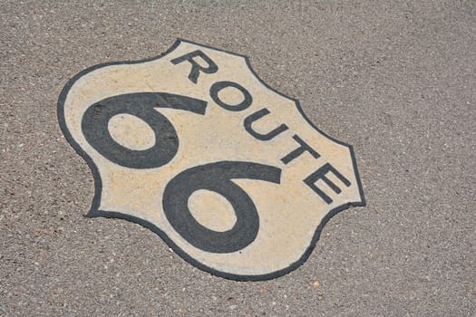 The mythical Route 66 sign, in road asphalt, USA.