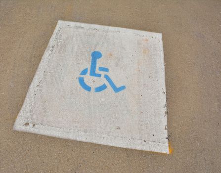 Disabled blue parking sign painted on asphalt.