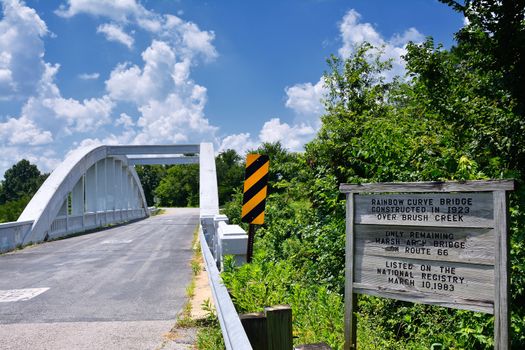 Close up of this Rainbow Curve Bridge Constructed in 1923 that is the only remaining Marsh Arch Bridge on Route 66. Route 66 signs are painted on the pavement.