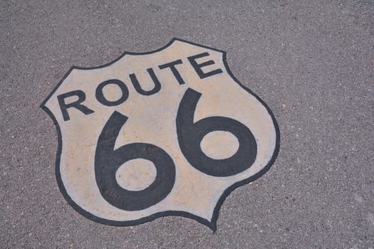 The mythical Route 66 sign, in road asphalt, USA.