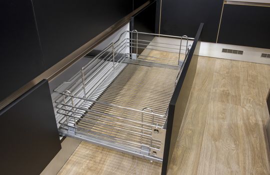 Interior design decor of kitchen in luxury apartment showing closeup detail of sliding metal drawer shelf