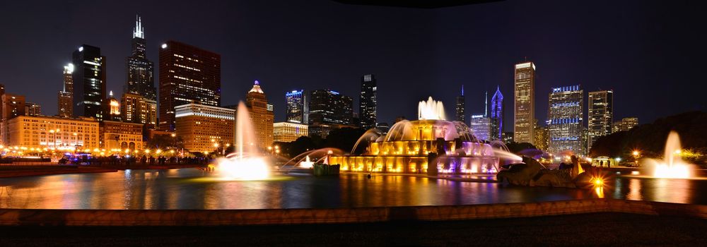 Chicago skyline panorama with skyscrapers and Buckingham fountain at night.