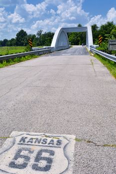 Close up of this Rainbow Curve Bridge Constructed in 1923 that is the only remaining Marsh Arch Bridge on Route 66. Route 66 signs are painted on the pavement.