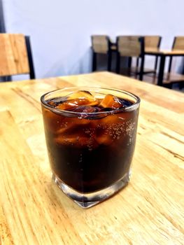 Cola in glass ice, Pouring cola from glass bottles drinks to a glass with ice cubes, cola in glass ice beverage Drinks on the restaurant table