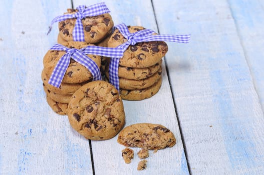 Stacks of homemade chocolate chip cookies on wooden table