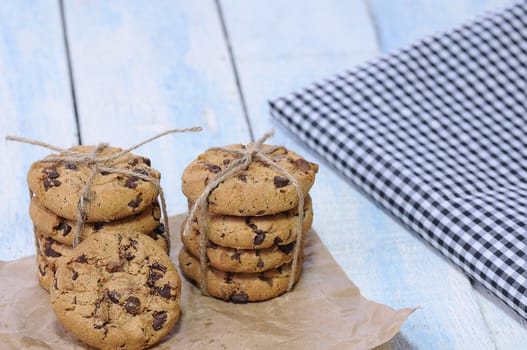 Stacks of homemade chocolate chip cookies on wooden table