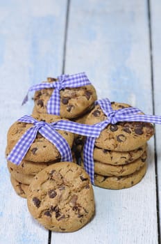 Stacks of homemade chocolate chip cookies on wooden table