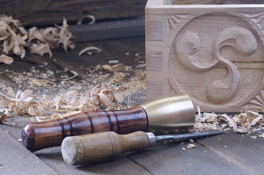 Chisel and hammer in front of carved wooden box
