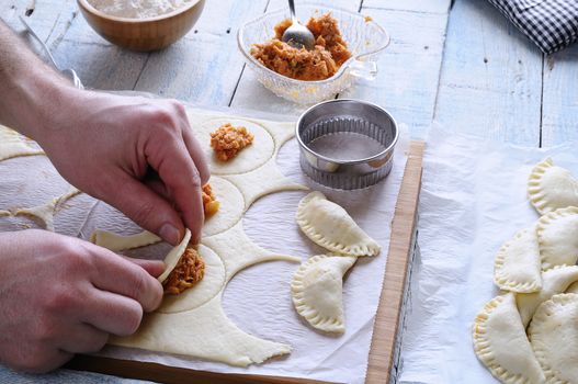 Man's hands making dumplings. Unrecognizable