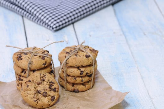 Stacks of homemade chocolate chip cookies on wooden table