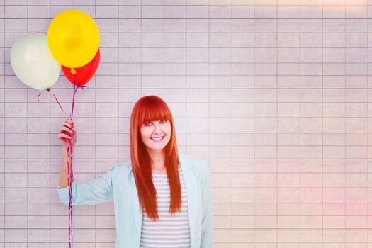 Smiling hipster woman holding balloons against textured background