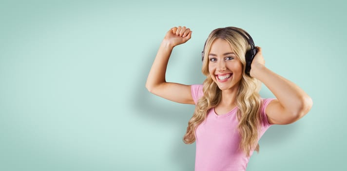 Portrait of a beautiful woman dancing with headphones against blue vignette background