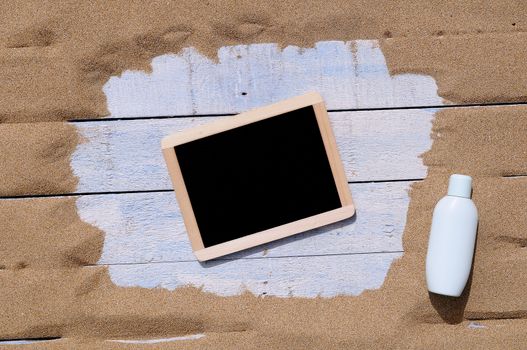 Black board in frame on blue wooden background. From above