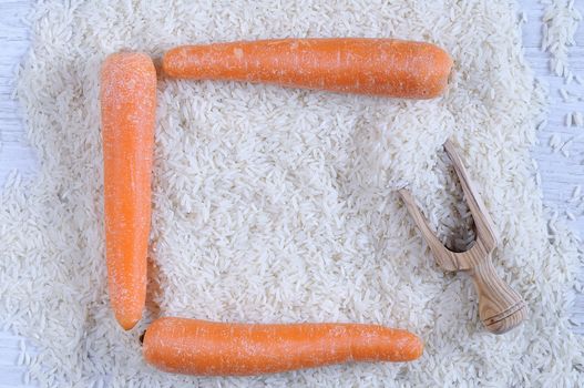 Three carrots on pile of white rice. From above