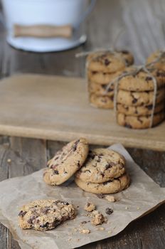 Stacks of homemade chocolate chip cookies on wooden table