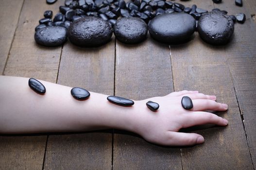 Someone's hand covered with spa stones. Unrecognizable