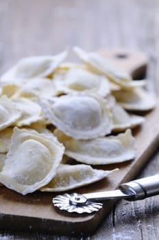 Close-up of homemade raw ravioli on wooden board in daylight