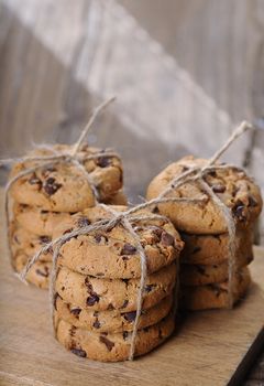 Stacks of homemade chocolate chip cookies on wooden table