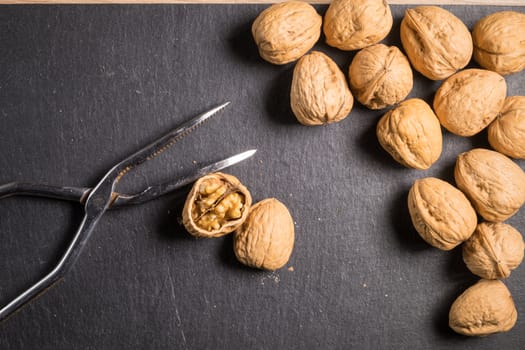 Walnuts with nutcracker on slate stone